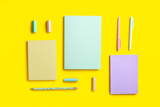 Stylish notebooks, pens, pencil and erasers on color background - Fotó, kép