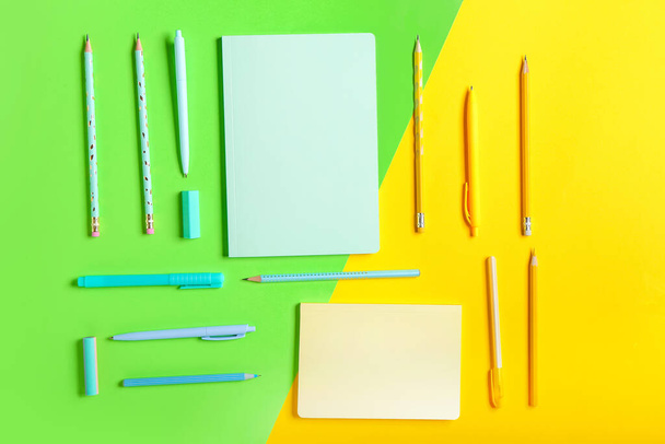 Notebooks, pens, pencils and erasers on color background - Fotoğraf, Görsel