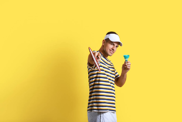 Sporty male badminton player on color background - Fotó, kép