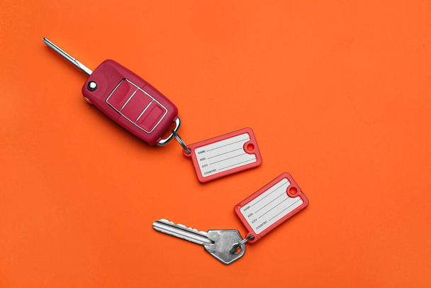 Различные ключи с пластиковыми метками на оранжевом фоне - Фото, изображение