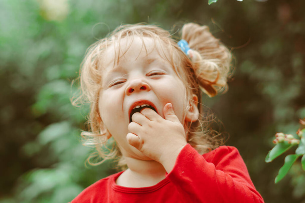 Niña comiendo grosellas en el jardín de verano - Foto, imagen