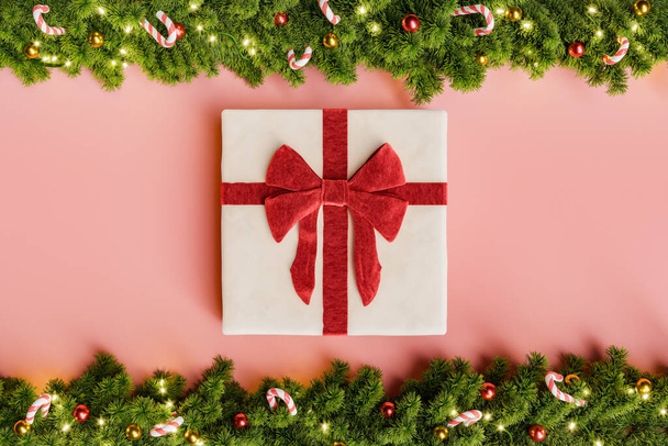 Weihnachtsgirlanden dekoriert mit Süßigkeiten, Kugeln und Lichtern und ein Geschenk in der Mitte mit roter Schleife. 3D-Darstellung - Foto, Bild