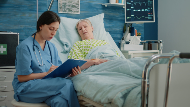 Pielęgniarka robi badania medyczne ze starszą kobietą w łóżku - Zdjęcie, obraz