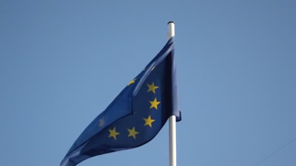Vlajka EU vlající ve větru proti modré obloze - Záběry, video
