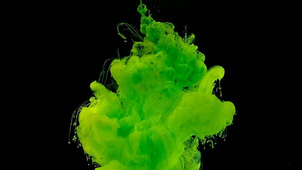 Green cloud of ink. Cosmic magic background. Beautiful abstract background. Green watercolor ink in water on a black background. Waves and drops of green colors. - Foto, imagen