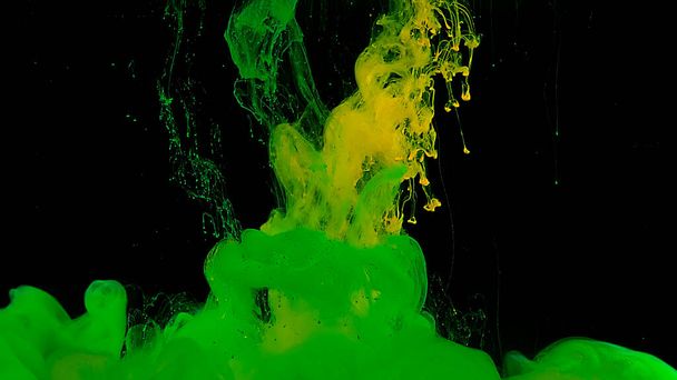 Beautiful abstract background. Green and yellow watercolor ink in water on a black background. Waves and drops of green and yellow colors. Green and yellow cloud of ink. Cosmic magic background. - Zdjęcie, obraz