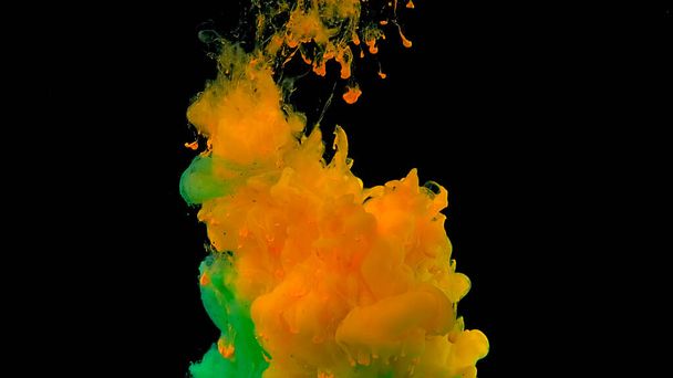 Beautiful abstract background. Green and yellow watercolor ink in water on a black background. Waves and drops of green and yellow colors. Cosmic magic background. Green and yellow cloud of ink. - Fotografie, Obrázek