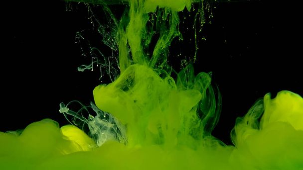 Beautiful abstract background. Green watercolor ink in water on a black background. Waves and drops of green colors. Green cloud of ink. Cosmic magic background. - Fotografie, Obrázek