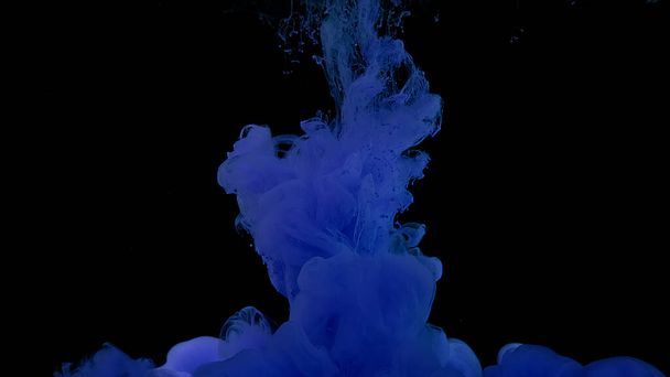 Purple watercolor ink in water on a black background. Waves and drops of violet paints. Cosmic magic background. Purple ink cloud. Beautiful abstract background. - Foto, Imagen