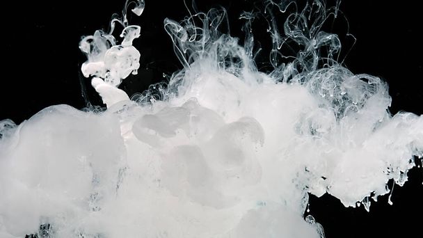 Meditative magic abstract background. White cloud of ink on a black background. White watercolor paints in water. White watercolor ink in water on a black background. - Foto, afbeelding