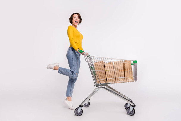 Full body photo of impressed brunette millennial lady do shopping wear shirt jeans isolated on grey color background - 写真・画像