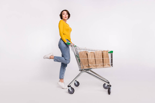 Full size profile side photo of young woman amazed store customer shopping bags isolated over grey color background - 写真・画像