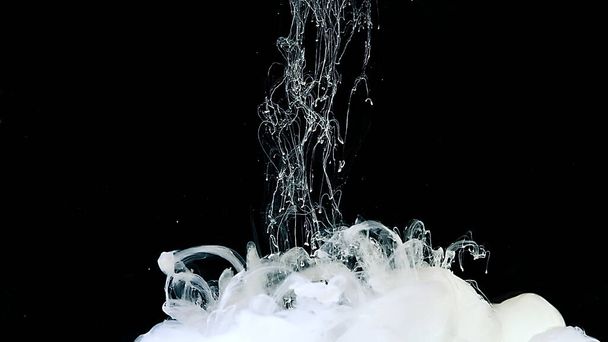 Cosmic magic abstract background. White watercolor paints in water. Drops of white ink in water. White cloud of ink on a black background. - Фото, зображення