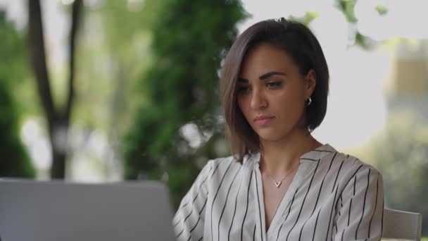 Mulher de negócios Morena Árabe Hispânica Etnia Funciona remotamente enquanto está sentado em um café de verão em um dia ensolarado. - Filmagem, Vídeo