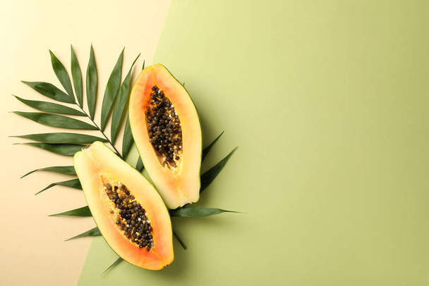 Ripe papaya with leaves on two tone background - Foto, imagen