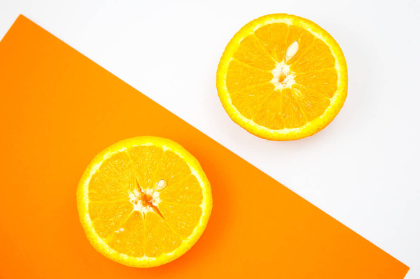 Close up photo of Orange Fruit on the white and orange background. Citrus cut in half, inside, macro view. Minimalism, original and creative image. Beautiful natural wallpaper. - Photo, Image