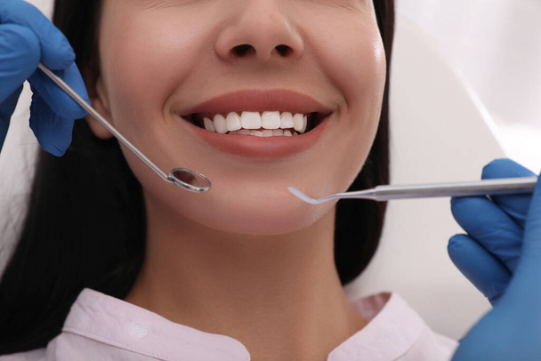 Dentist examining young woman's teeth, closeup view - Zdjęcie, obraz