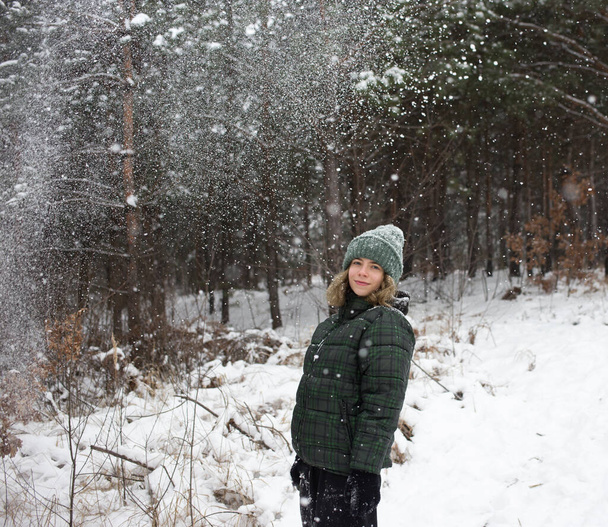 söpö teini tyttö hyvällä tuulella seisoo taustalla lumen peittämä maa, lumihiutaleet lentävät. kylmä sää. talvilomat. Nauttii hetkestä, hymyilee. Rakkaus Talvi - Valokuva, kuva