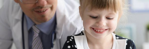 Little girl sitting at visit of man doctor in clinic - Photo, Image