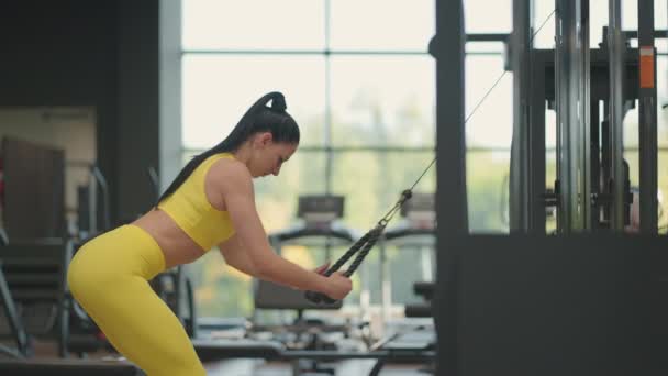 Esmer kadın spor salonunda sırtını ve omuzlarını çalıştırıyor. Sırtınızı ve omuz sağlığınızı kontrol edin. El egzersizi - Video, Çekim