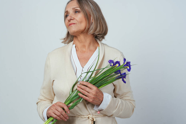anciana en un vestido con un ramo de flores cuidado de la memoria - Foto, Imagen