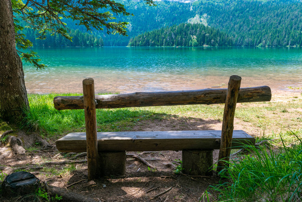 Wooden bench near Glacial Black Lake. Premium tourist attraction of Durmitor National Park. Walking path circles around lake, and is popular destination for recreation and hiking. Montenegro - Fotó, kép