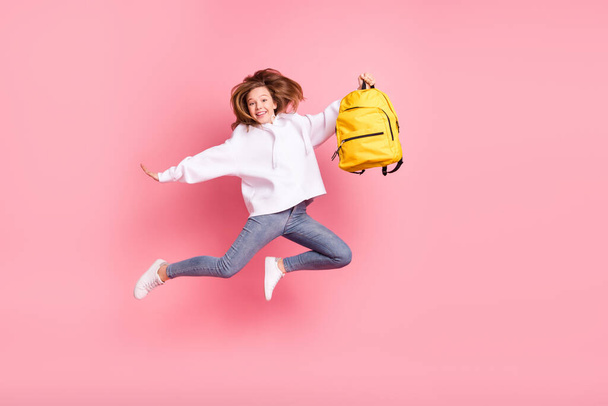 Vista completa del tamaño del cuerpo de la atractiva chica alegre de moda saltando bolsa de sujeción engañando aislado sobre fondo de color pastel rosa - Foto, imagen