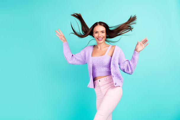 Photo of excited inspired lady enjoy carefree time wind blow hair wear violet cardigan isolated teal color background - Photo, Image