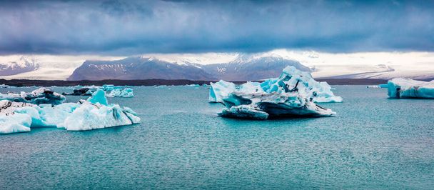 Patos árticos entre icebergs azules en la laguna glacial de Jokulsarlon. Atardecer dramático de verano en el Parque Nacional Vatnajokull, al sureste de Islandia, Europa. Belleza de la naturaleza concepto fondo. - Foto, Imagen