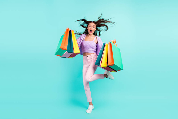 Photo of excited funny lady hold store bags scream open mouth wear purple cardigan isolated turquoise color background - 写真・画像