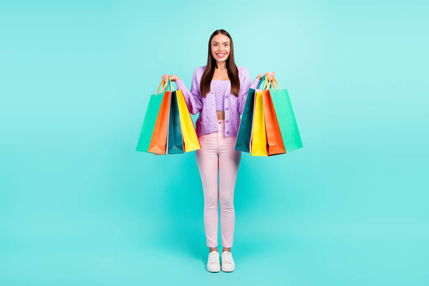 Photo of cheerful customer lady hold retail packages wear violet cardigan isolated turquoise color background - Fotografie, Obrázek