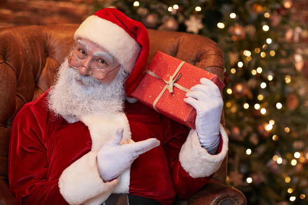 Weihnachtsmann schenkt - Foto, Bild