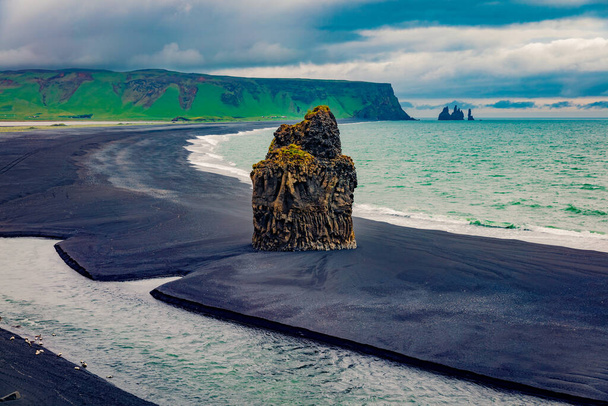 自然保護区の完璧な夏の景色-レイニスフィヤラビーチ、ヴィクの場所、アイスランド、ヨーロッパ。黒砂のビーチとレイニストランガー崖を背景に大西洋の悲観的な朝の海の風景.  - 写真・画像