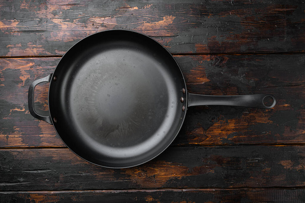 Cast iron frying pan set with copy space for text or food with copy space for text or food, top view flat lay, on old dark  wooden table background - Zdjęcie, obraz