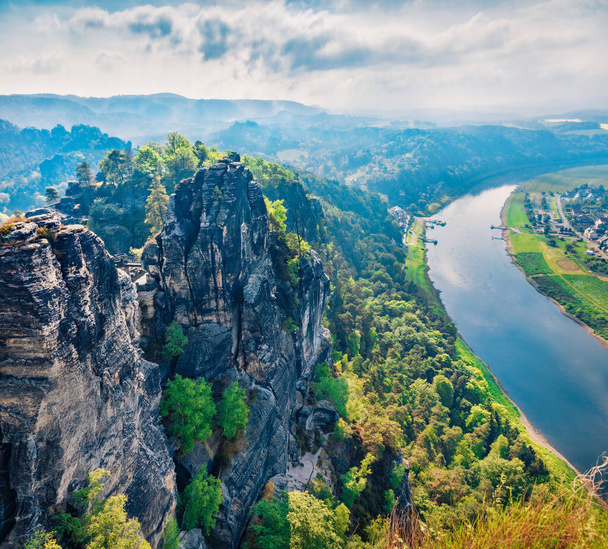 Aerial summer view of Rathen village from viewpoint of Bastei in Saxon Switzerland Germany. Amazing morning scene of Sandstone Mountains, Saxony, Germany, Europe. Traveling concept background. - Foto, Imagem