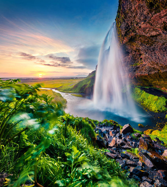 Turistlerin akarsuların ardında yürüyebileceği Seljalandsfoss adında turistik bir yer. İzlanda, Avrupa 'nın inanılmaz yaz manzarası. Doğa konseptinin güzelliği. - Fotoğraf, Görsel