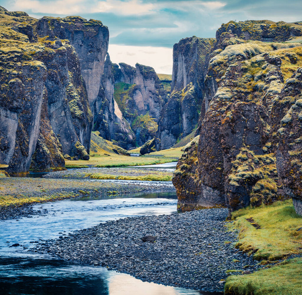Θολή καλοκαιρινή θέα του φαραγγιού Fjadrargljufur και του ποταμού. Υπέροχη σκηνή μεσονύκτιου ήλιου της νοτιοανατολικής Ισλανδίας, της Ευρώπης. Ομορφιά της φύσης έννοια φόντο. - Φωτογραφία, εικόνα