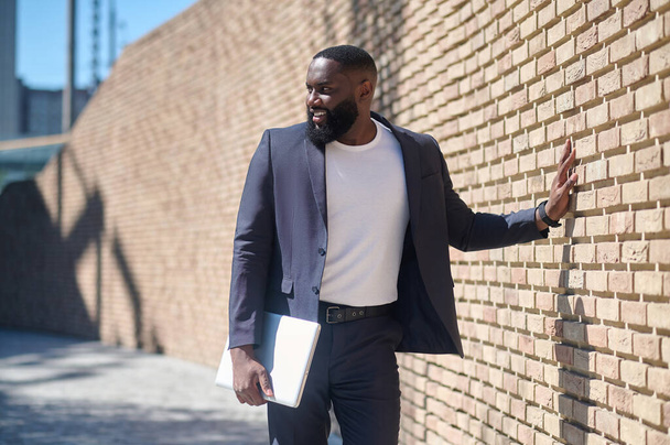 An african american man in a suit standing near the brick wall - Fotografie, Obrázek