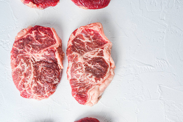 Roh geschnittenes Steak. Bio-Rindfleisch. Weißer strukturierter Hintergrund. Draufsicht mit Platz für Text - Foto, Bild
