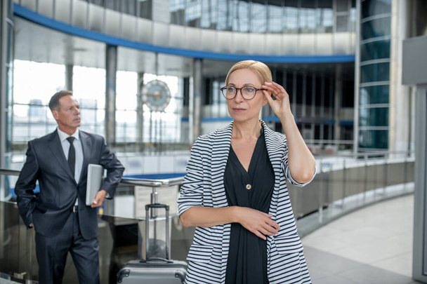 Serious business woman with glasses and colleague behind - 写真・画像