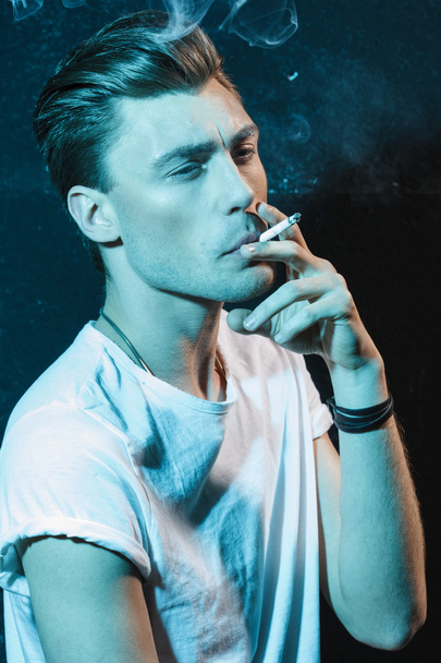Handsome young man smoking cigarette - Zdjęcie, obraz