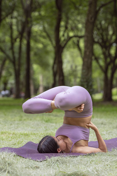 緑の芝生の上の公園でヨガの練習をしているメキシコ人女性 - 写真・画像
