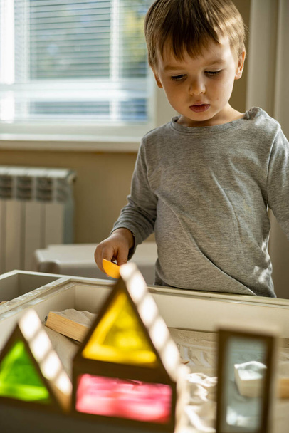 Cute toddler playing self development home kinetic sandbox use Maria Montessori method - Фото, изображение