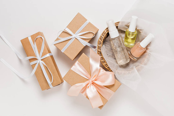 Organic cosmetics and gifts for the holiday. Flat lay, top view clear glass pump bottle, brush jar, moisturizing serum jar in a paper basket on a white background. Natural cosmetics SPA - Φωτογραφία, εικόνα