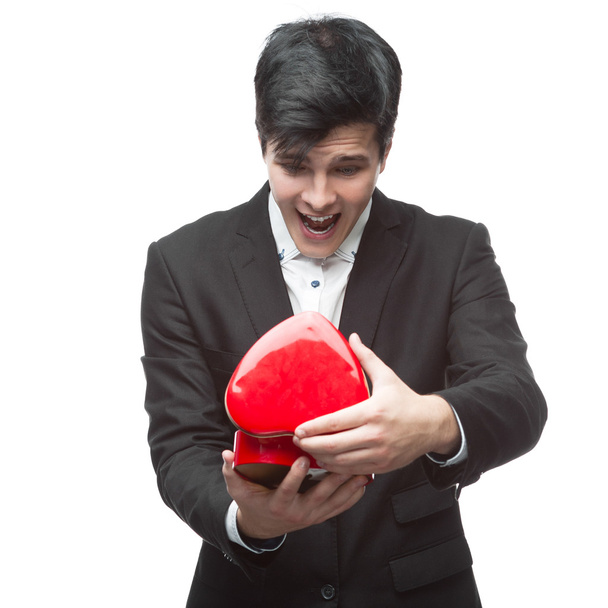 surprised businessman holding red heart - Фото, изображение
