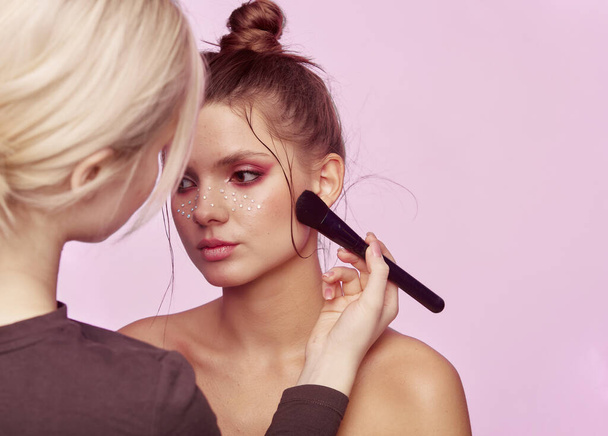 Visagist und Friseur bereitet schöne junge Frau im Schönheitssalon macht Mode Make-up - Foto, Bild