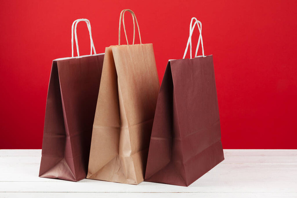 Several shopping bags with copy space on red background - Foto, Imagem