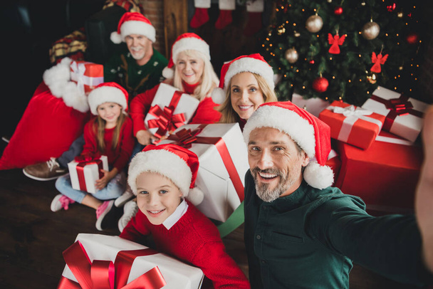 Photo portrait of big full family wearing red cap smiling together xmas spirit keeping presents dad taking selfie - Фото, изображение