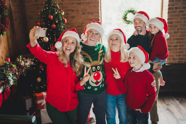 Photo portrait of full family spending time together near christmas tree taking selfie showing v-sign gesture - Fotografie, Obrázek