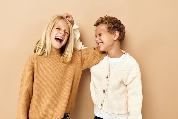 kislány és fiú mosolyog és pózol alkalmi ruhák Stúdió érzelmek - Fotó, kép